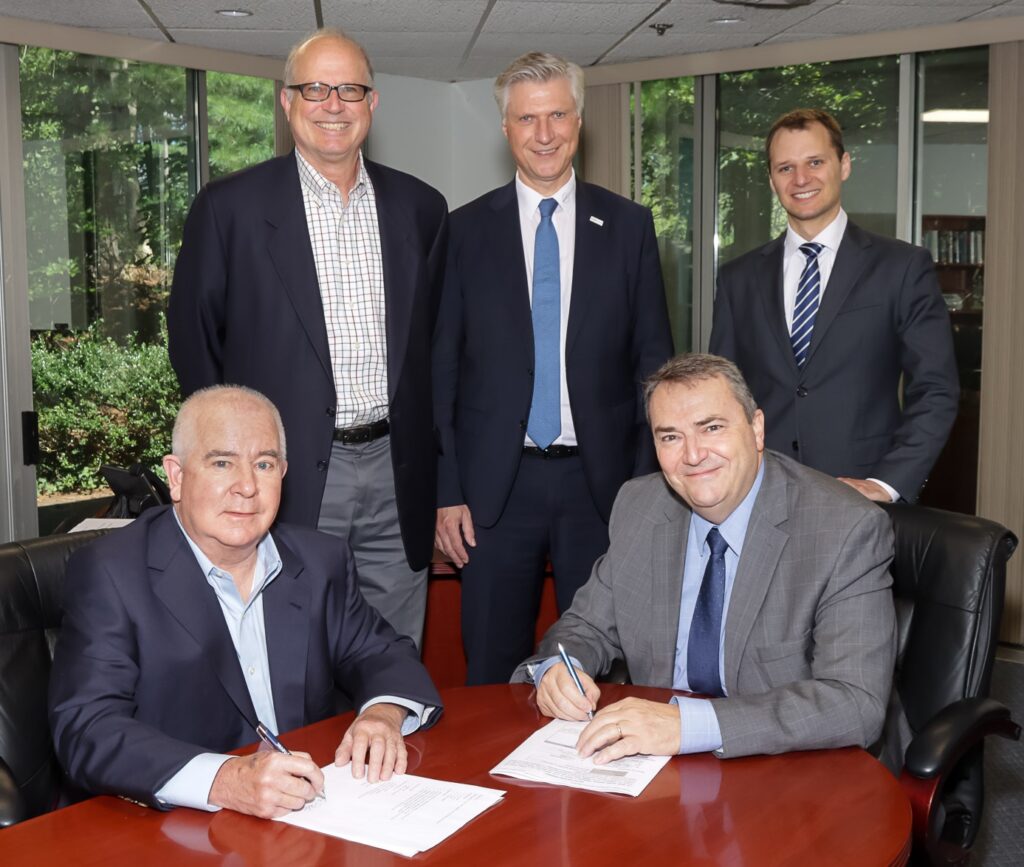 Robert Levert and Tom Foley sign documents for Weiss Technik's acquisition of Dynavac